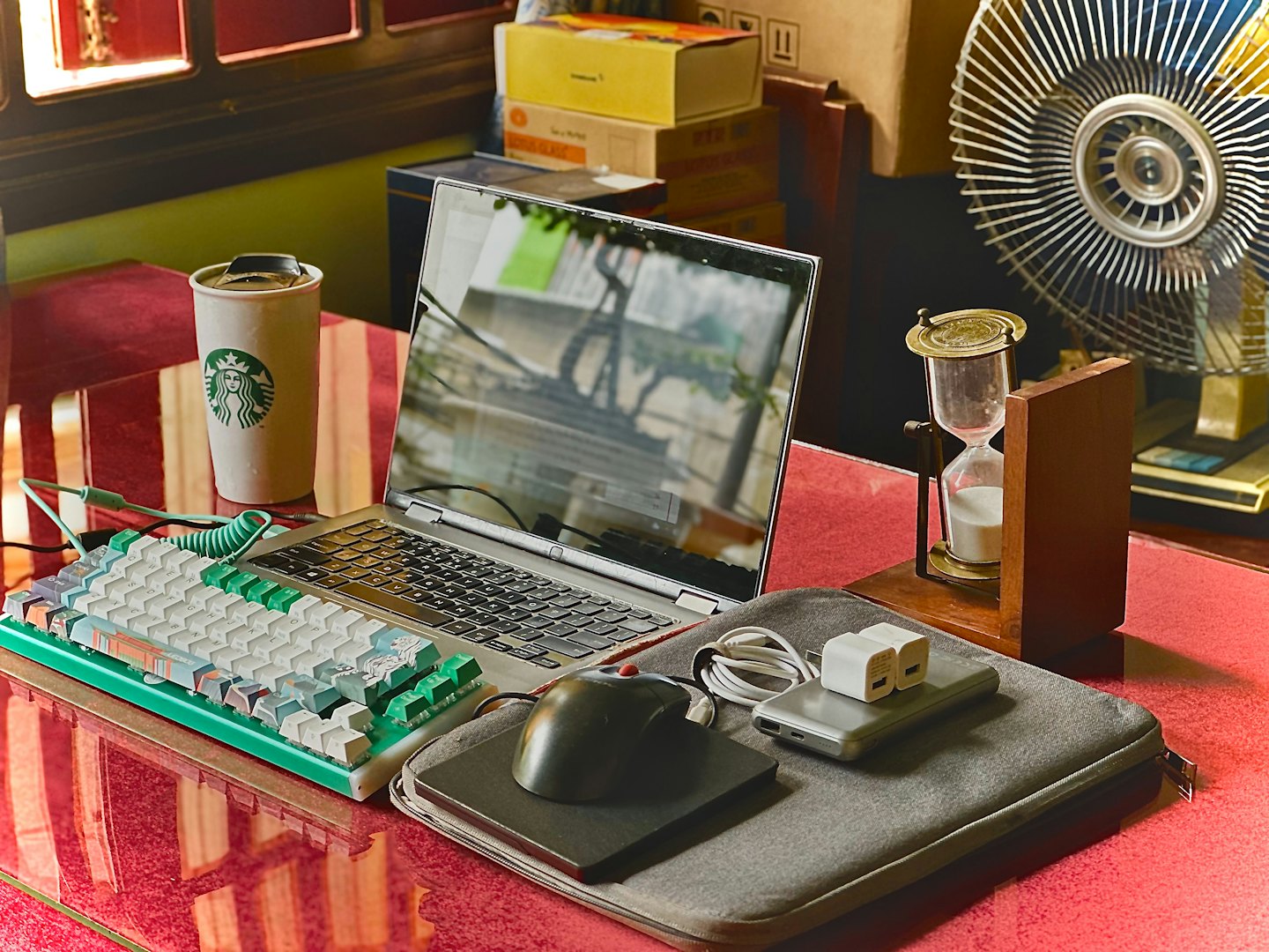 Laptop and keyboard setup on a desk with coffee.
