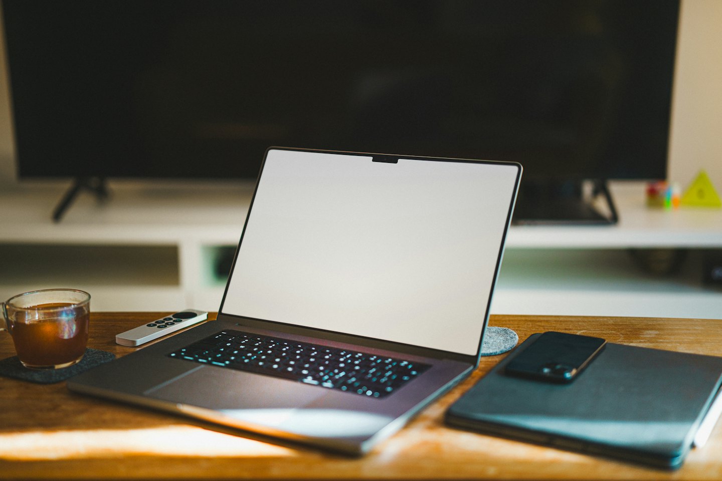 Modern laptop with blank screen on a wooden home office desk.